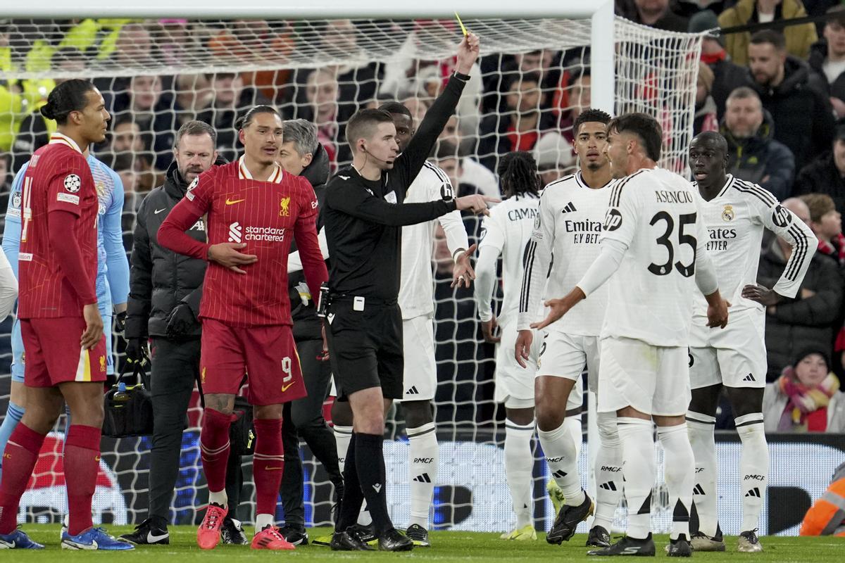 Referee Francois Letexier shows a yellow card to Liverpool's Darwin Nunez, 2nd left, and Real Madrid's Raul Asencio during the Champions League opening phase soccer match between Liverpool and Real Madrid at Anfield Stadium, Liverpool, England, Wednesday, Nov. 27, 2024. (AP Photo/Jon Super)