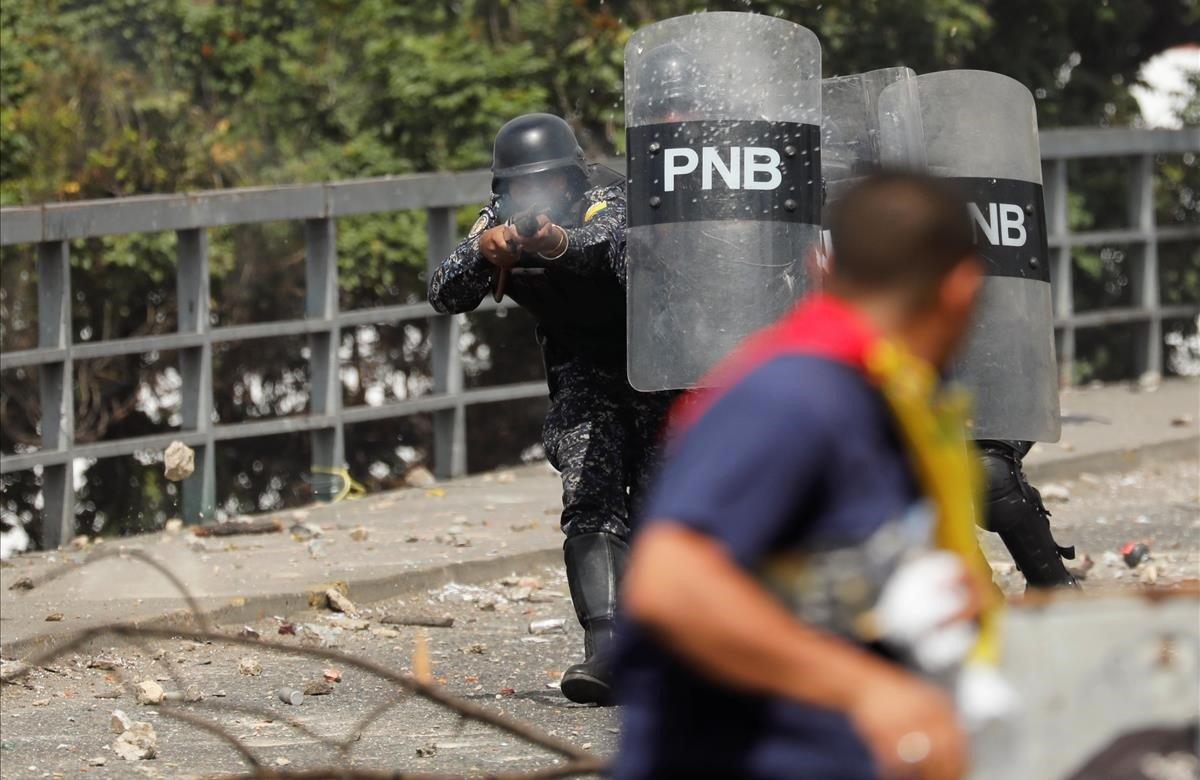 Un oficial de la Policía Nacional dispara balas de goma durante una protesta contra el gobierno del presidente venezolano Nicolás Maduro en Caracas.