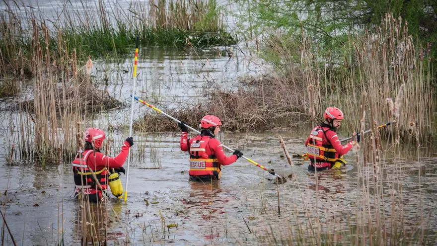 Efectivos de Cruz Roja acceden al río con pértigas para buscar al menor en el Guadiana