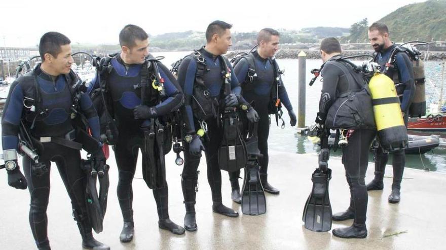 Grupo de buceo de la Guardia Real en el puerto de Candás, ayer, después de una inmersión.