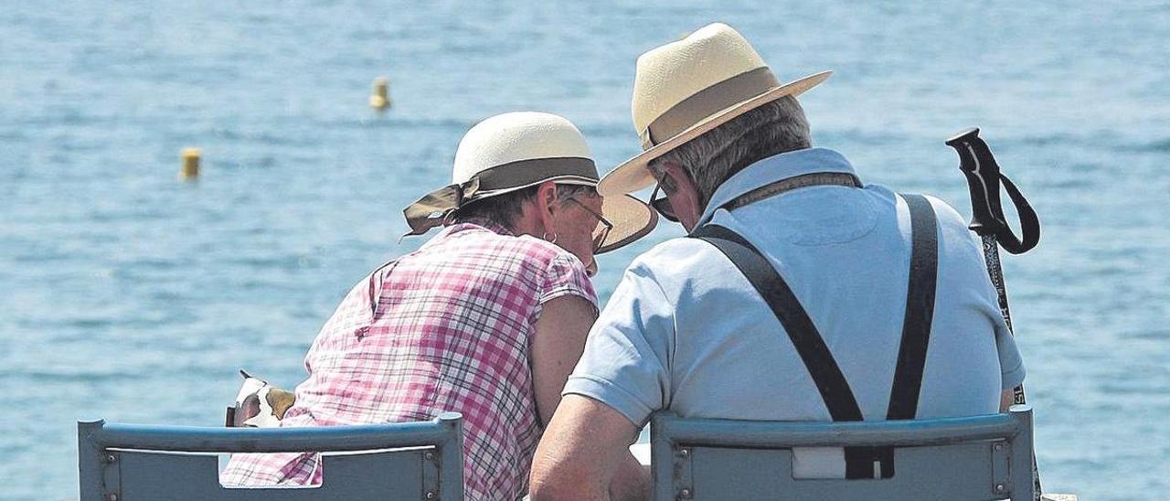 Una pareja de jubilados charla frente a la orilla del mar. La pensión de los que se retiran es cada vez más alta.