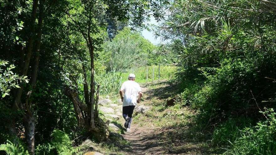 Un vecino, corriendo por el sendero que sigue el curso del río de Os Ladróns. // Gonzalo Núñez