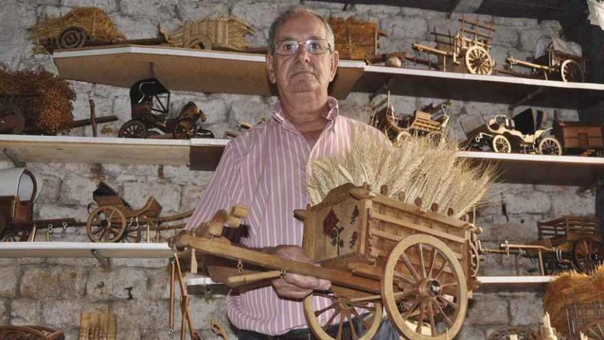 Pablo Calvo Olivera posa con la reconstrucción de un típico carro de siega.