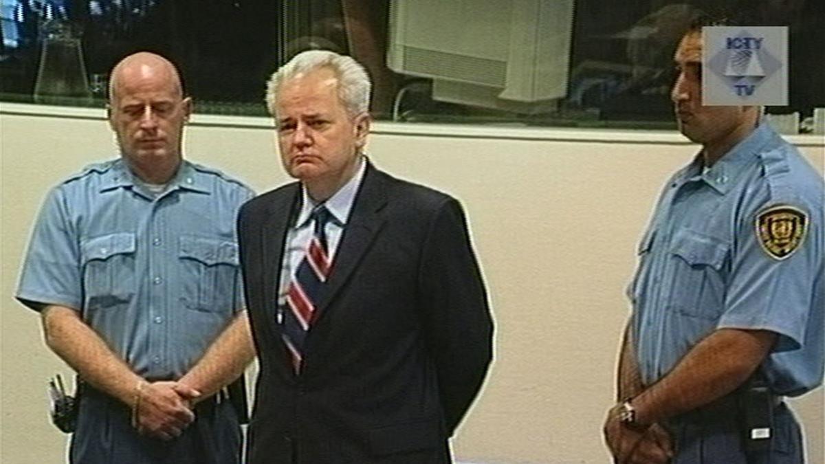 Slobodan Milosevic (centro), expresidente de Serbia, junto a dos guardias de seguridad antes de comparecer en el TPIY, en La Haya, el 3 de julio del 2001.