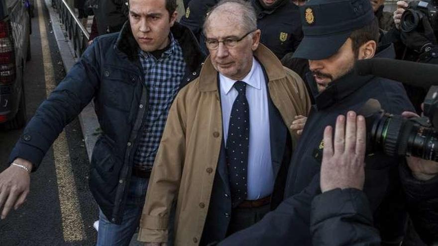 Rato, rodeado por guardaespaldas y policías, a su salida, ayer, del juzgado, en Madrid. // Efe