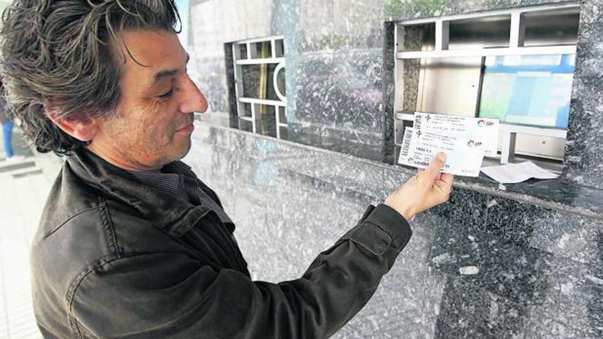 Un aficionado retira las entradas reservadas a través de internet. // Marta G. Brea