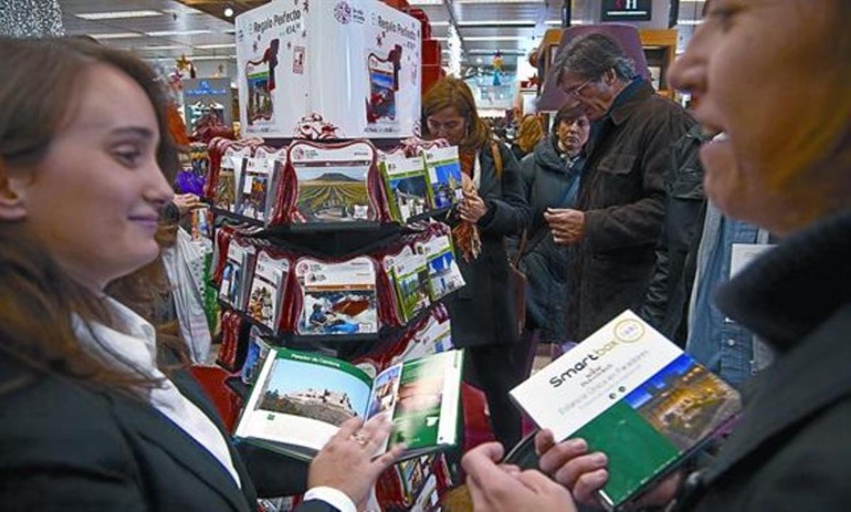 Diversos clients s’interessen per les caixes regal a El Corte Inglés de la plaça de Catalunya. Diversos clients s’interessen per les caixes regal a El Corte Inglés de la plaça de Catalunya.