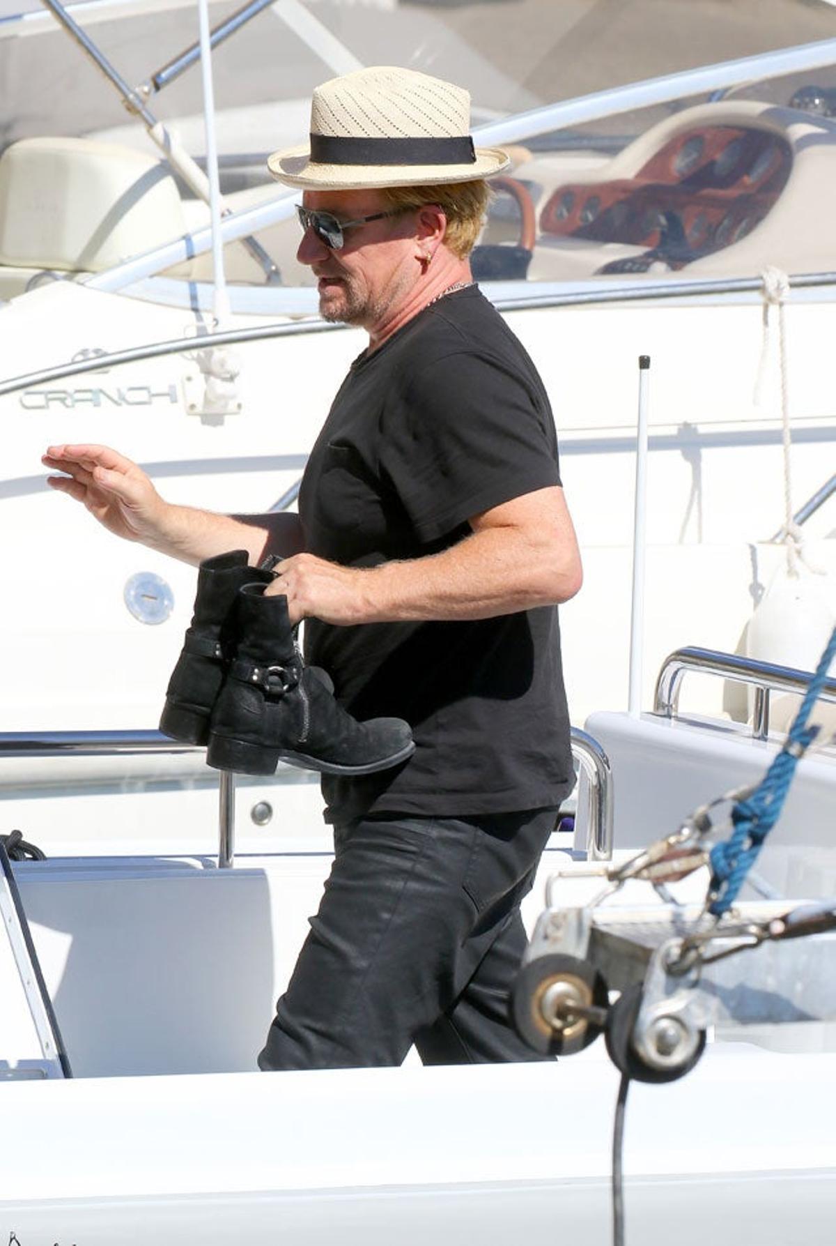 Bono con sus botas en la mano antes de salir del yate