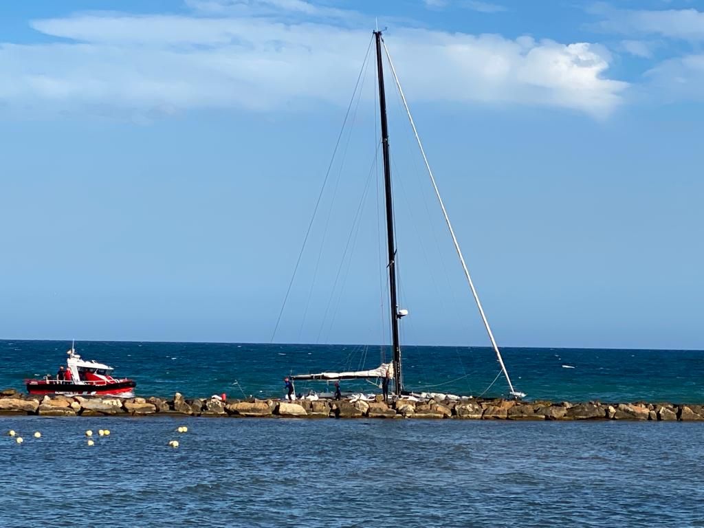 Un velero encalla en las rocas de la escollera de la playa del Cocó