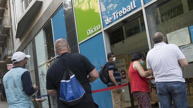 Persones a l’atur fan cua davant una oficina del SEPE a Barcelona per ser atesos.