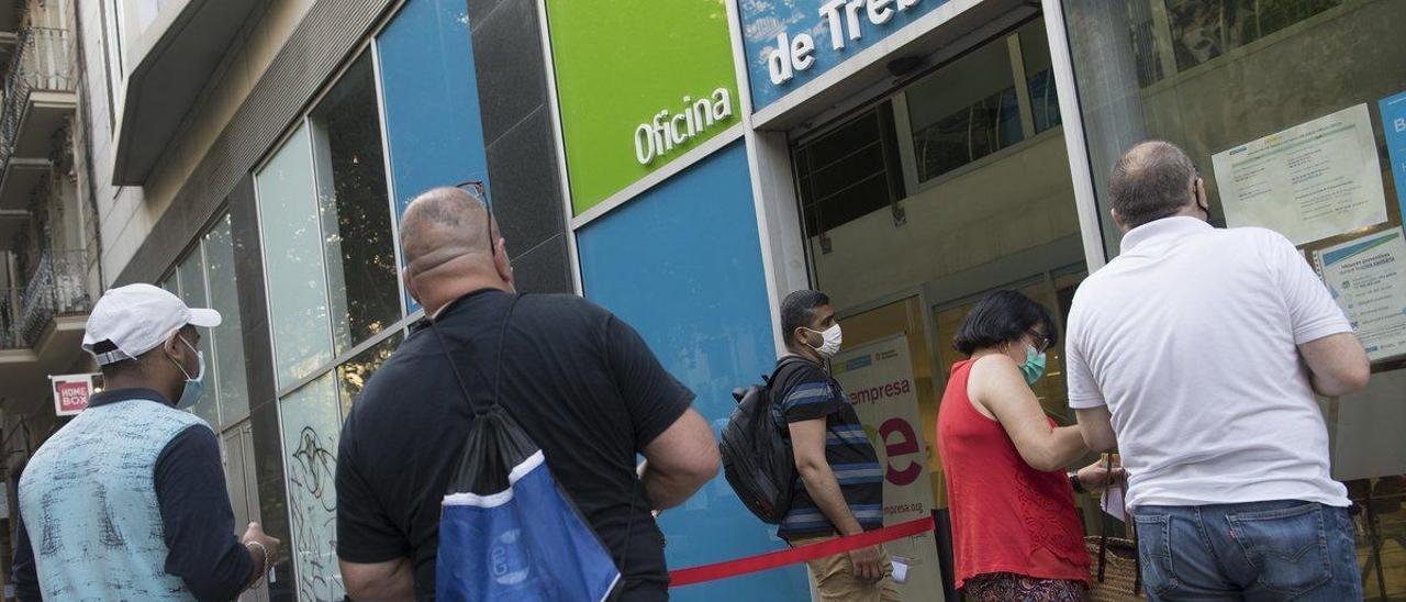 Personas en paro hacen cola frente a una oficina del SEPE en Barcelona para ser atendidos.