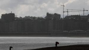 GRAFCAV6407. SAN SEBASTIÁN (ESPAÑA), 09/06/2020.- Unas personas se protegen con paraguas este martes en la playa de Ondarreta en San Sebastián. Los cielos en Euskadi se presentan nubosos o cubiertos con lluvias débiles y chubascos, poco probables en el sur de Álava y más intensas y persistentes en Gipuzkoa y que irán cesando por la tarde, cuando se abrirán claros, temperaturas en ligero ascenso y vientos del noroeste, flojos en general en el interior y más intensos en el litoral. EFE/Juan Herrero