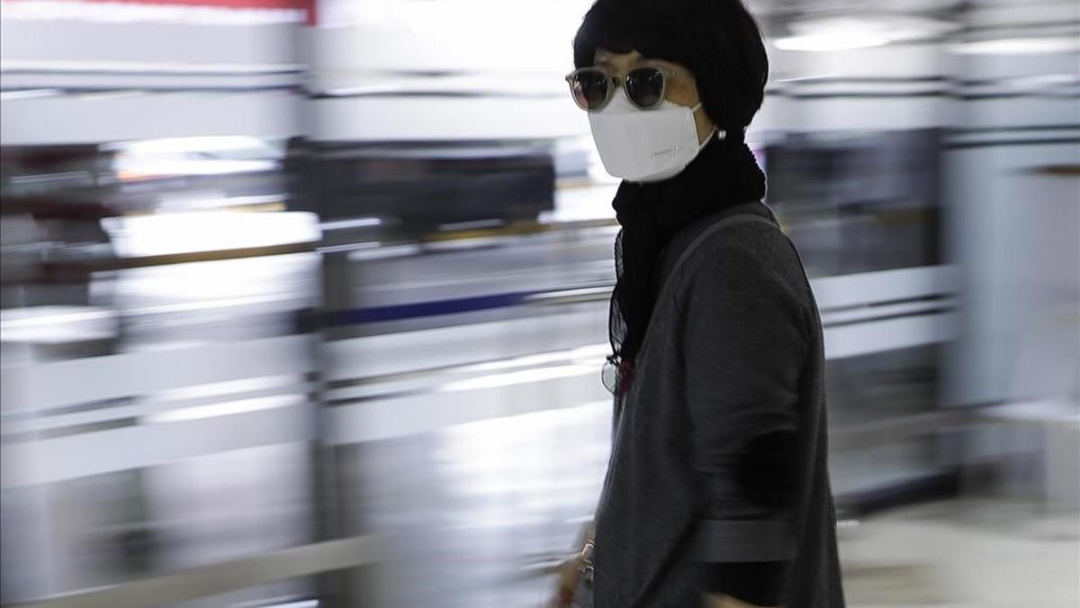 Una mujer se protege con una máscara en el aeropuerto internacional de Manila