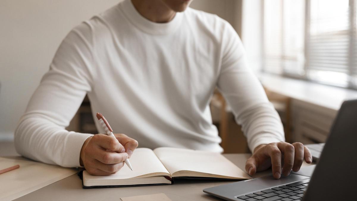 Imagen de archivo de un joven opositor estudiando con un ordenador.