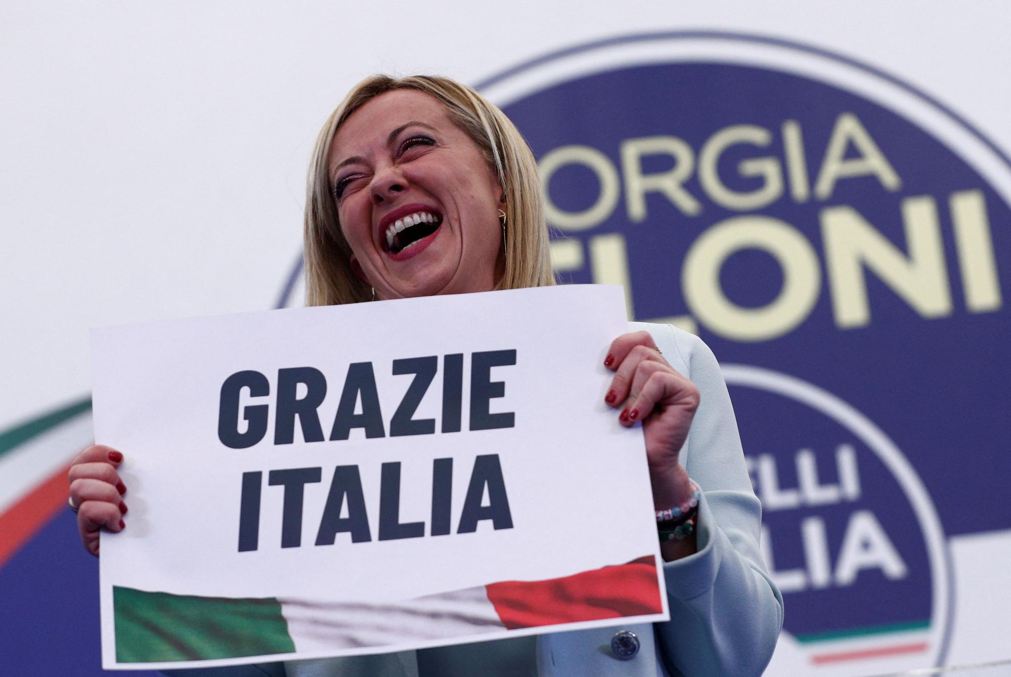 Giorgia Meloni sostiene un cartel en el que se lee &quot;Gracias, Italia&quot; para celebrar su victoria.