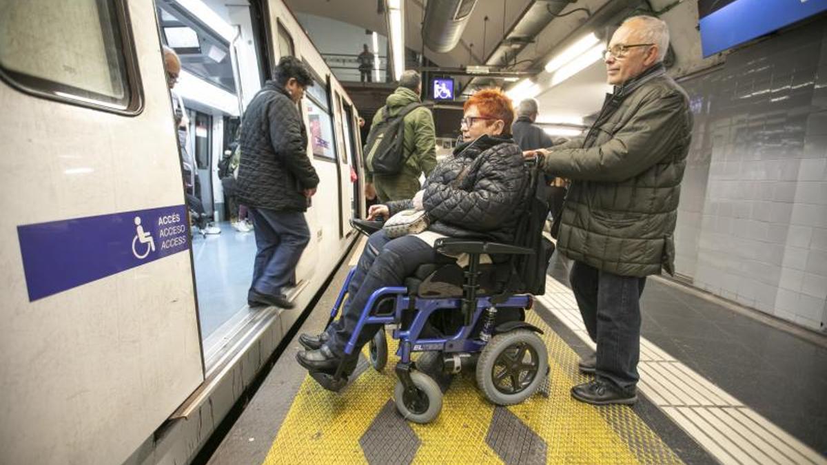 Una mujer en silla de ruedas accede al Metro de Madrid.
