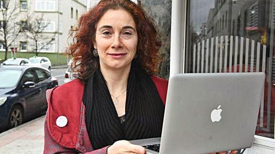 Paula Recarey, con su ordenador portátil, en una cafetería.