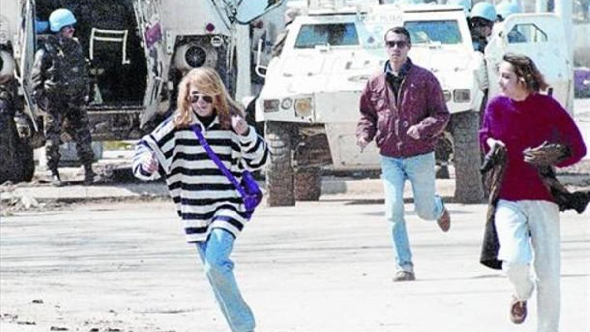 PASADO Y PRESENTE. Varios peatones cruzan la denominada «avenida de los francotiradores» corriendo para tratar de evitar se alcanzados por algún disparo, en Sarajevo, mientras los cascos azules de la ONU vigilan, en abril de 1995.