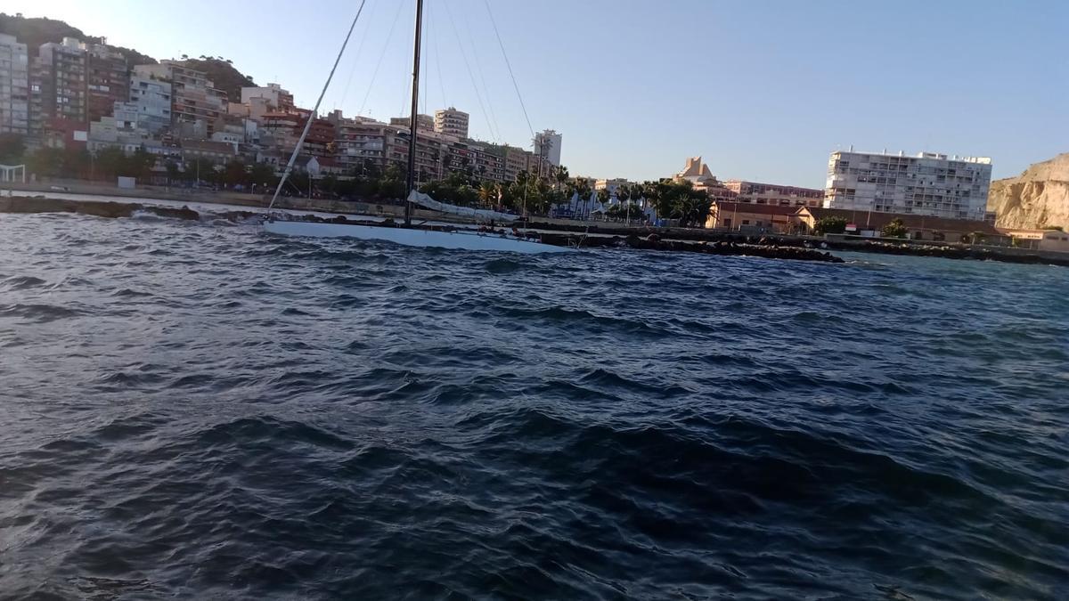 Un velero encalla en las rocas de la escollera de la playa del Cocó.