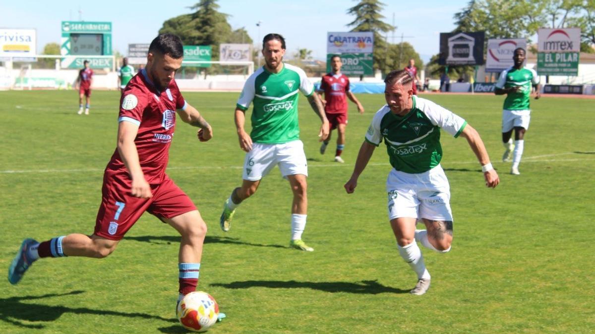 Bermúdez busca tiro en el área del Villanovense ante dos contrarios.