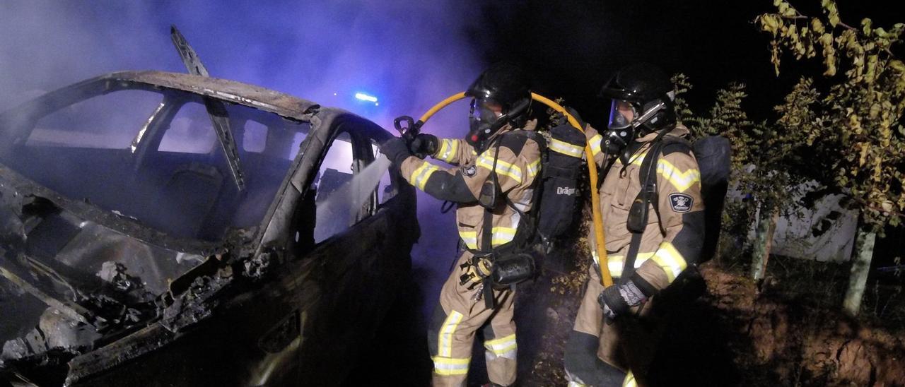 Una imagen de los bomberos sofocando el fuego del todoterreno incendiado intencionadamente para borrar las huellas