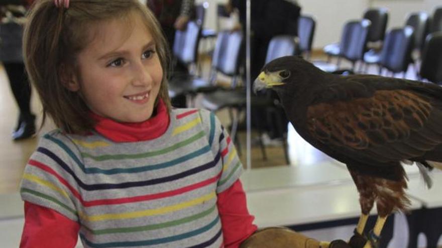 Paola, una de las niñas, posa junto al águila real al final de la charla.