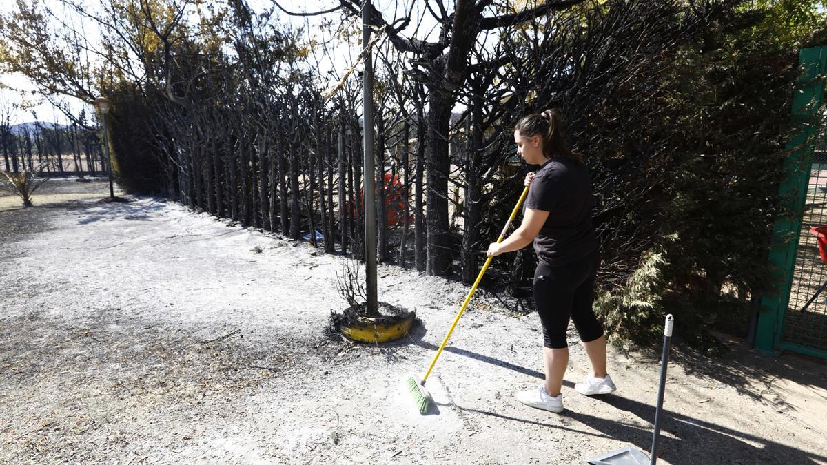 Una joven barre la ceniza en las piscinas de Vera de Moncayo.