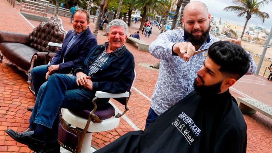 José Eduardo Ramírez y Pedro Quevedo junto a uno de los barberos solidarios.