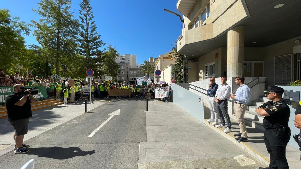 El concejal y el alcalde en el acceso del Ayuntamiento rodeados por los docentes tras las protesta