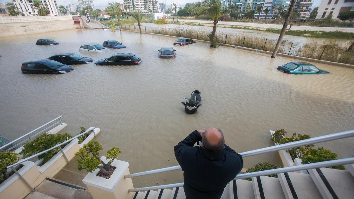 Un hombre observa un aparcamiento anegado por las lluvias de 2017 en Alicante