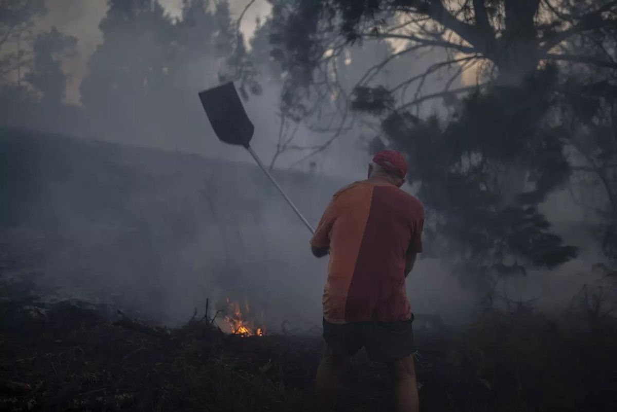 Un vecino combate las llamas con un 'batelumes', tras el incendio de 2022 en Verín.