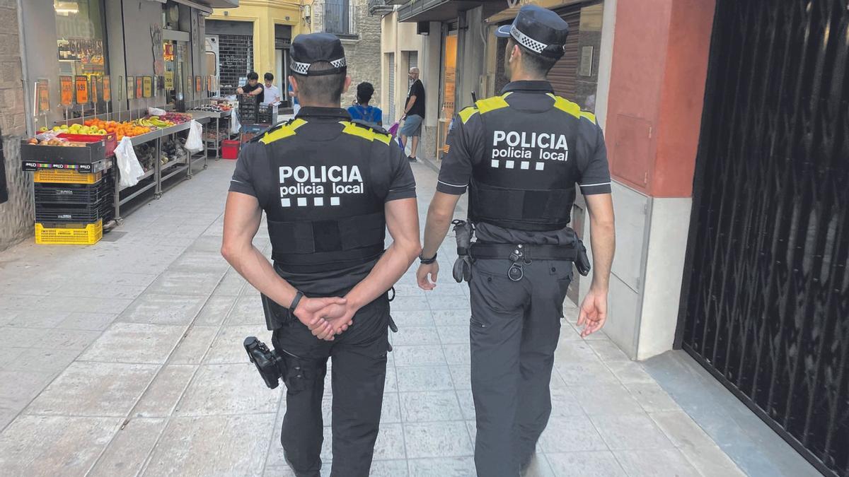 Dos agents de la Policia Local de Banyoles realitzant tasques de seguretat ciutadana al centre de la ciutat