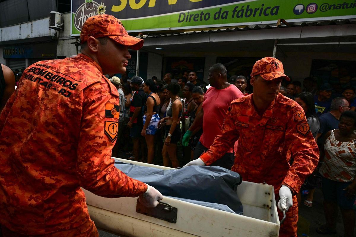 EDITORS NOTE: Graphic content / Firefighters carry a body on Sao Lucas Square of the Vila Cruzeiro favela at the Penha complex in Rio de Janeiro, Brazil, on October 29, 2025, in the aftermath of Operacao Contencao (Operation Containment). Residents of a favela in Rio de Janeiro lined up more than 50 bodies at a plaza in their low-income neighborhood on Ocotber 29, a day after the bloodiest police operation in the citys history, AFP reported. (Photo by Pablo PORCIUNCULA / AFP). Graphic content