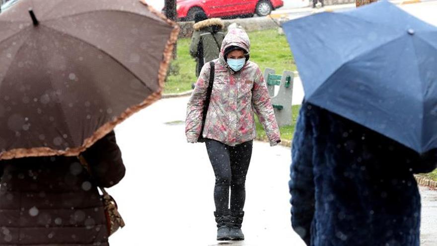 Unas personas caminan bajo la lluvia