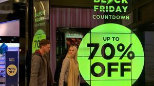 People walk past a sign advertising Black Friday offers at a perfume store in Manchester, Britain November 20 2019. Picture taken November 20, 2019. REUTERS/Phil Noble