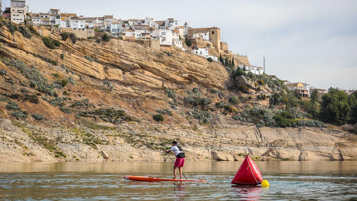 Un hombre practica paddle surf en el pantano de Iznájar.