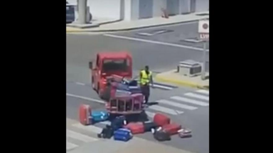 Un operario del aeropuerto de Eivissa lanza al aire las maletas de los pasajeros