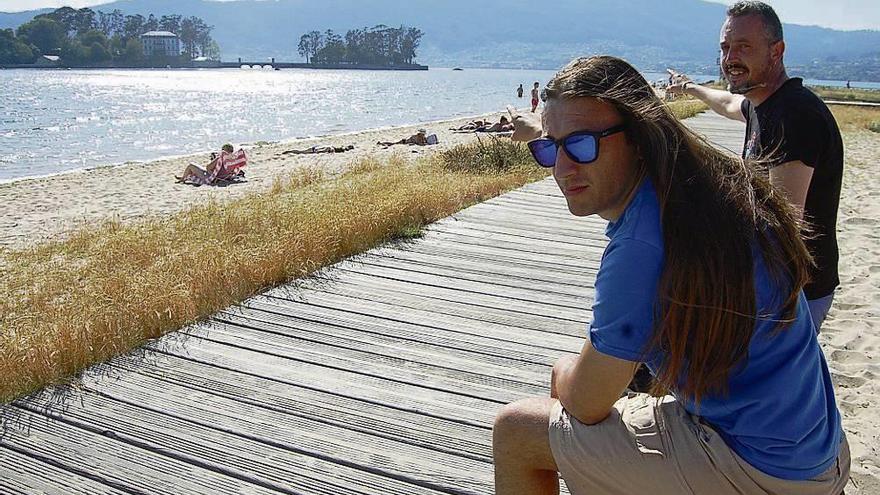 Cristobal Infante e Iván Casal, ayer, ante la zona del rescate, en la playa de Cesantes. // FdV