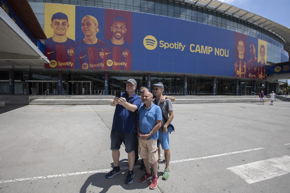 Un grupo de turistas posan ante la lona del nuevo Spotify Camp Nou.