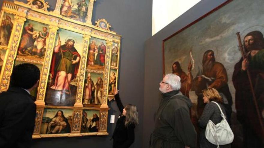 Visitantes observan el retablo de Santa Bárbara que se exhibe en &quot;Camins d&#039;Art&quot;.