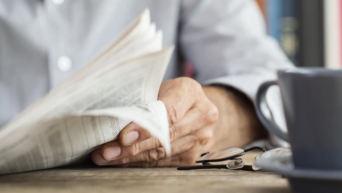 Un hombre lee un periódico.