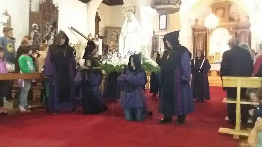 Los cofrades cargan de rodillas con la Virgen en el interior de la iglesia de Manganeses de la Lampreana.