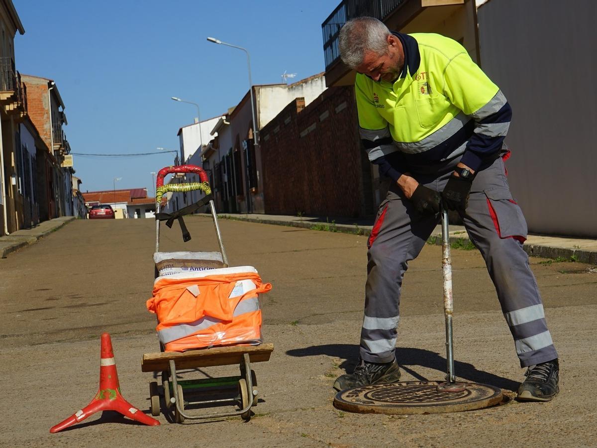 Operario de Promedio realizando un tratamiento preventivo contra ratas y cucarachas en una alcantarilla.