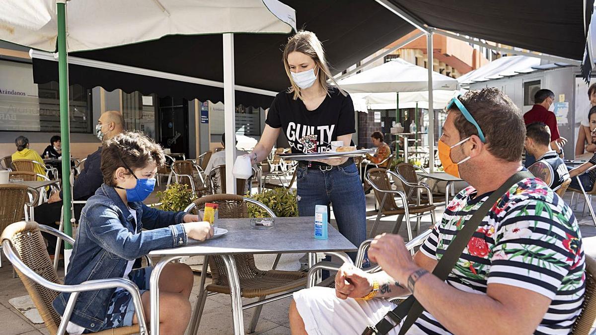 Una camarera atiende una mesa en una terraza de la capital.