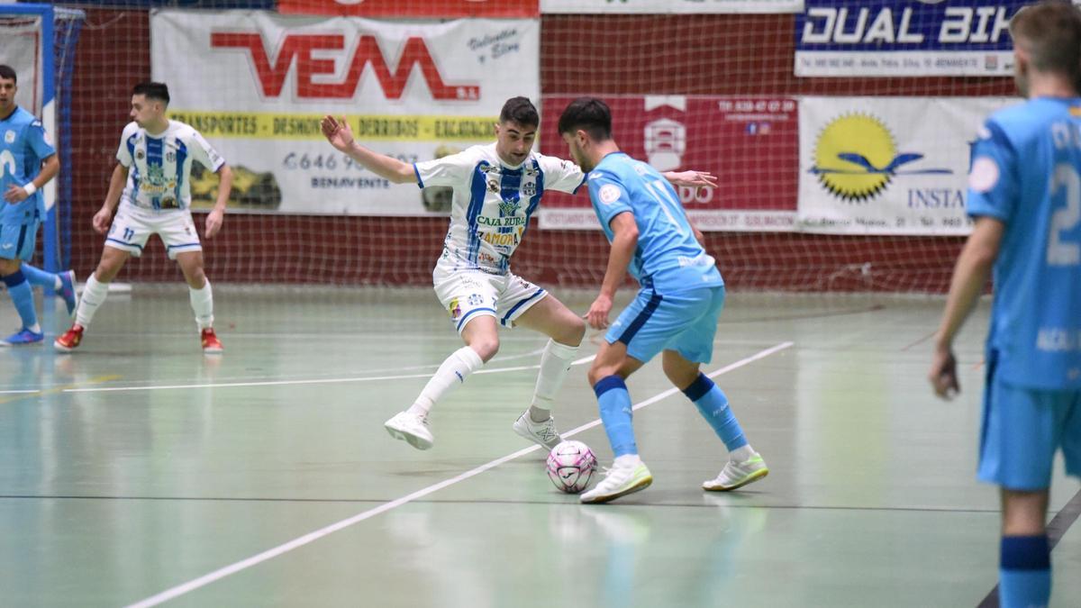 Un jugador del Atlético Benavente trata de frenar a un adversario.