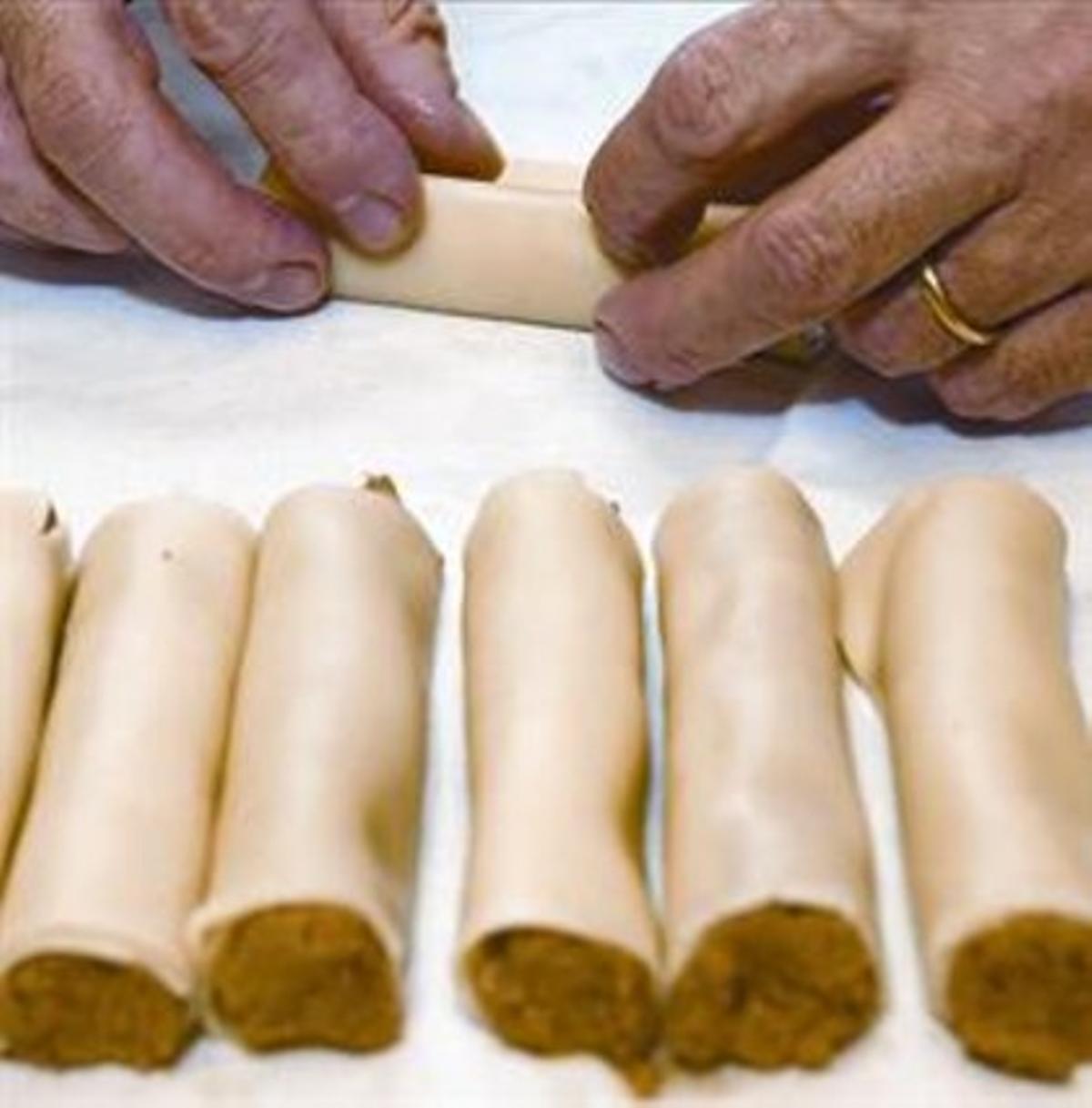 Un home prepara canelons. Un home prepara canelons.