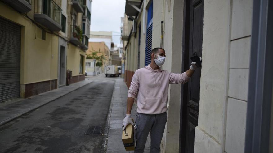 Un hombre con un paquete de Amazon toca un telefonillo.