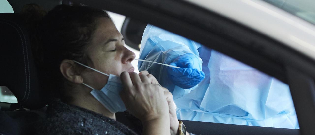 Una sanitaria le realiza la prueba PCR a una mujer en su coche.