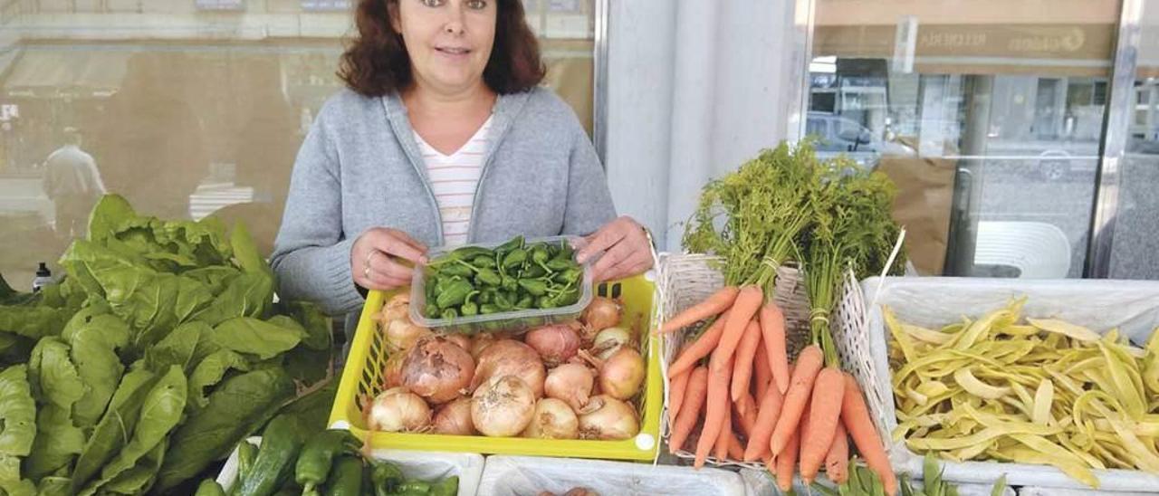 Merce Pérez, ayer, en la Pola, en su puesto, en el que abundan pimientos, judías verdes y amarillas y tomates.