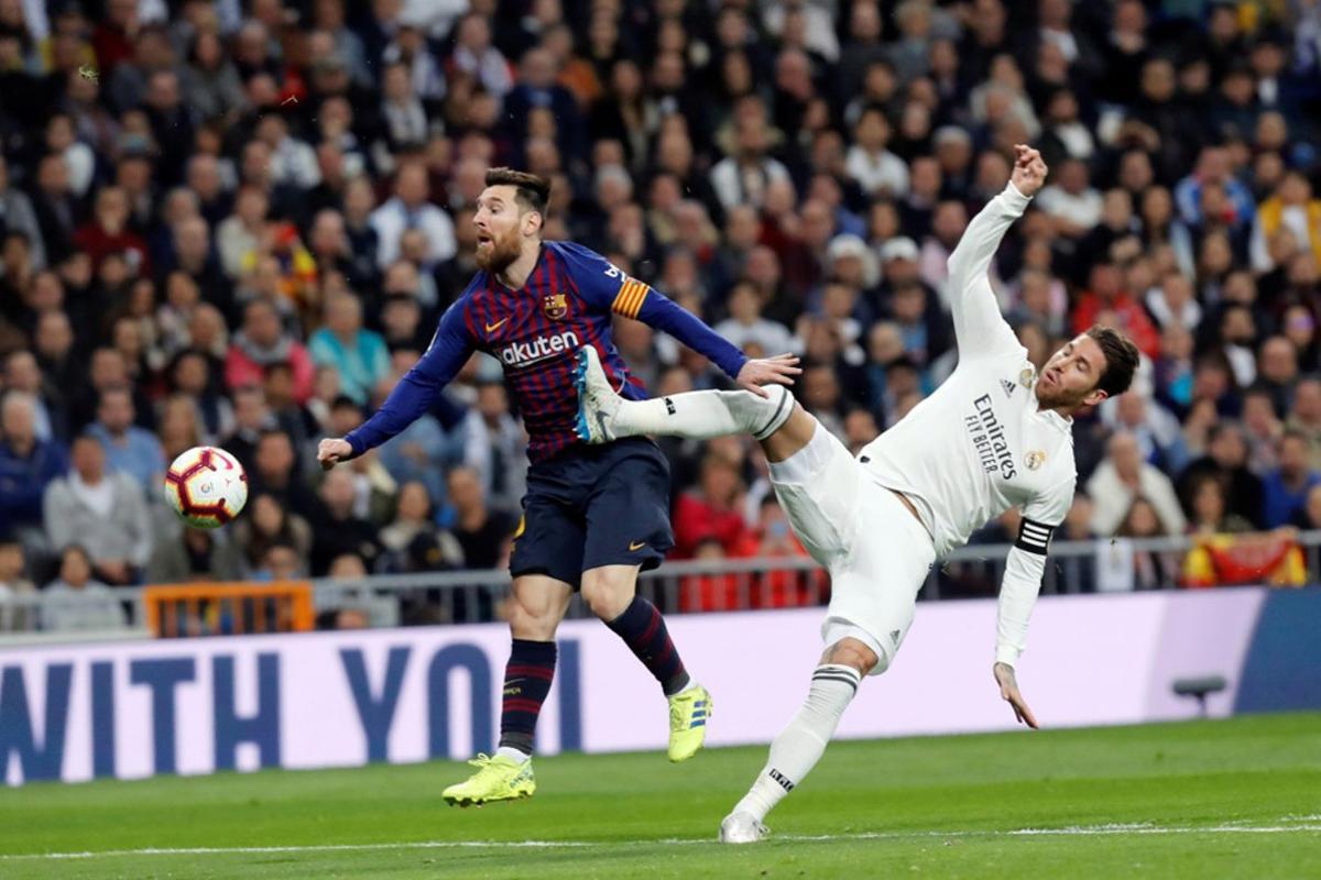 Sergio Ramos (d) lucha con Leo Messi durante el partido entre el Real Madrid y el FC Barcelona en el Estadio Santiago Bernabéu de la jornada 26 de La Liga.